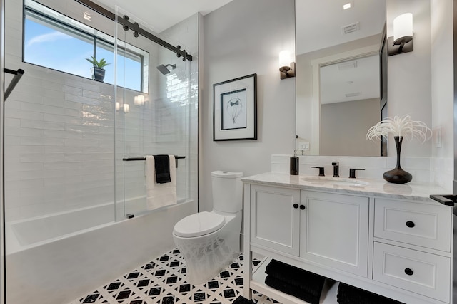 bathroom featuring visible vents, toilet, tile patterned floors, combined bath / shower with glass door, and vanity