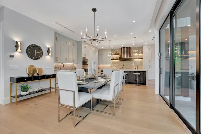 dining room with light wood-style flooring, a notable chandelier, and recessed lighting