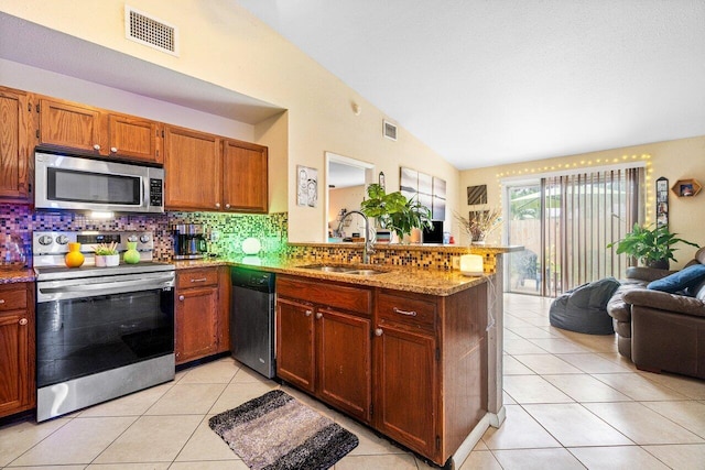 kitchen featuring sink, lofted ceiling, kitchen peninsula, and stainless steel appliances