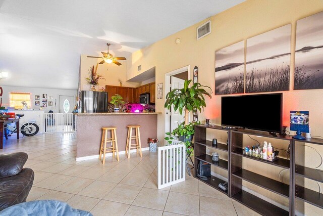 tiled living room featuring ceiling fan