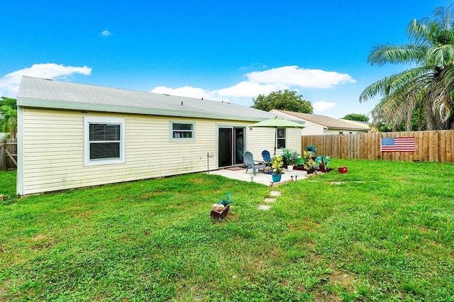 back of property with a patio and a yard