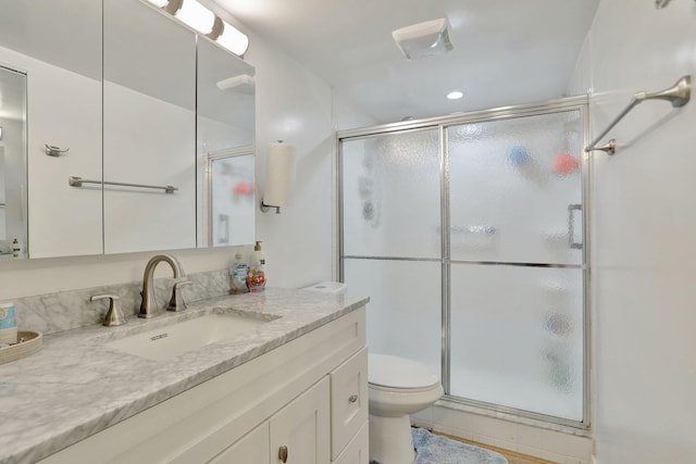 bathroom featuring walk in shower, vanity, and toilet