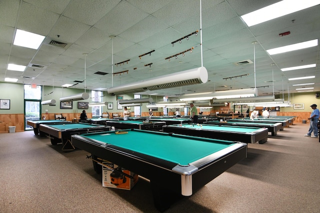 rec room featuring carpet floors, a drop ceiling, pool table, and wooden walls