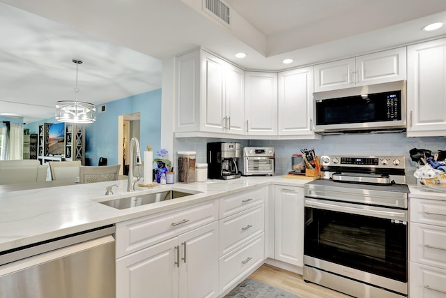 kitchen with white cabinets, appliances with stainless steel finishes, and sink