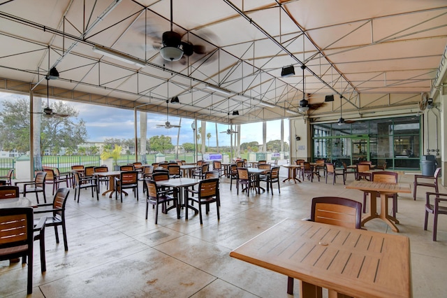 dining room with ceiling fan and a wall of windows