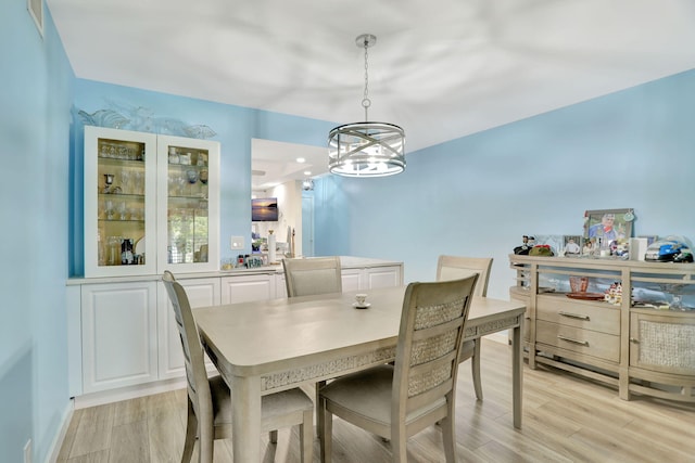 dining area with a chandelier and light hardwood / wood-style floors