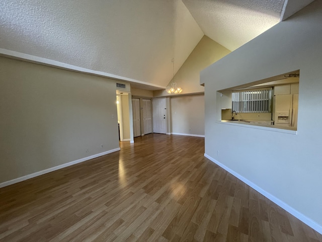 unfurnished living room featuring high vaulted ceiling, a textured ceiling, and wood-type flooring