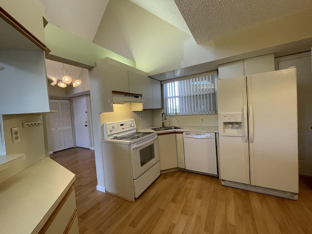 kitchen featuring sink, white appliances, light wood-type flooring, and decorative light fixtures