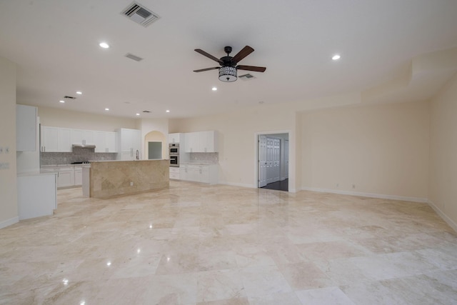 unfurnished living room featuring ceiling fan and sink