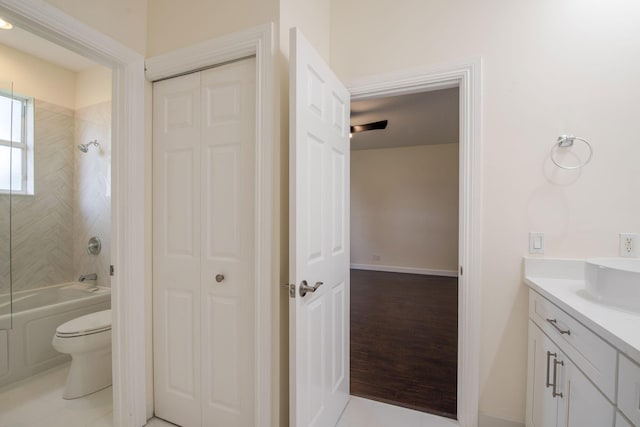 full bathroom featuring toilet, vanity, tiled shower / bath combo, and tile patterned flooring