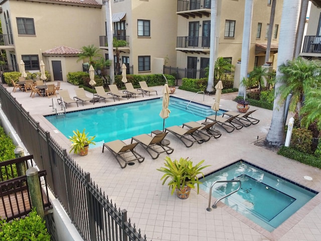 view of pool with a hot tub and a patio