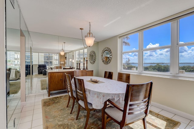 dining space with light tile patterned floors and a textured ceiling