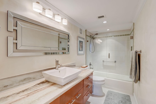 full bathroom featuring crown molding, tiled shower / bath, toilet, vanity, and tile patterned floors