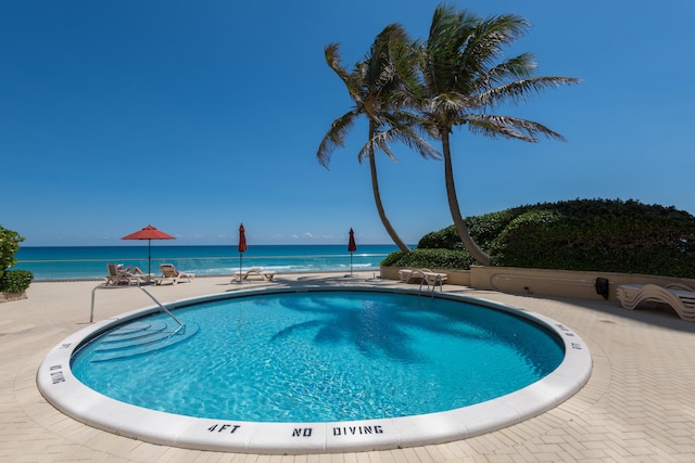 view of swimming pool featuring a water view