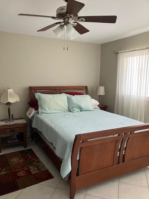 bedroom with light tile patterned flooring and ceiling fan