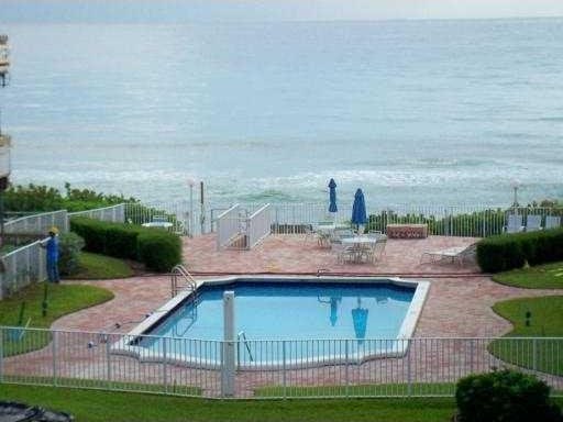 view of pool with a patio and a water view