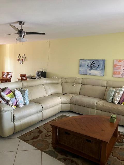 living room with tile patterned flooring and ceiling fan