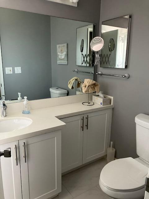 bathroom featuring vanity, tile patterned floors, and toilet