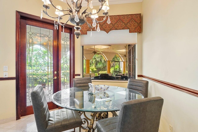 tiled dining room with a healthy amount of sunlight and ceiling fan with notable chandelier