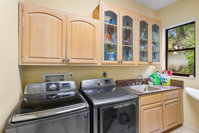 clothes washing area with cabinets, sink, and washing machine and dryer