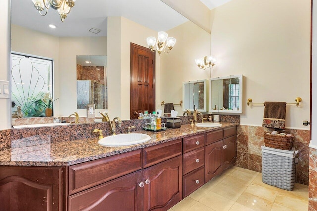 bathroom featuring an inviting chandelier, tile walls, tile patterned floors, and vanity