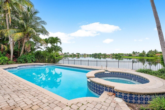 view of pool with a water view and an in ground hot tub