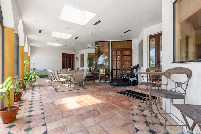 interior space with ceiling fan and french doors