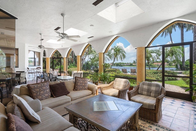 living room with ceiling fan and a skylight