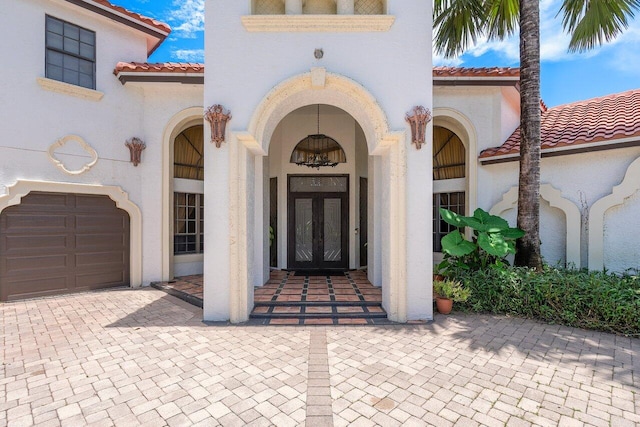 view of exterior entry featuring french doors and a garage