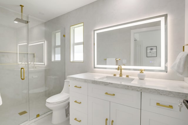 bathroom with a shower with door, vanity, and toilet