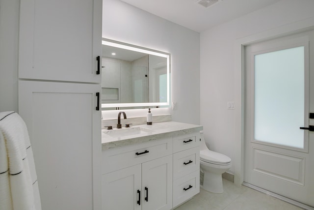 bathroom featuring toilet, vanity, and tile patterned flooring