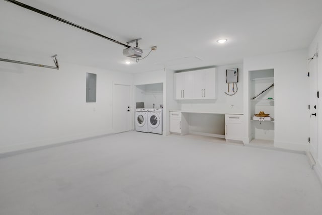 garage with electric panel, independent washer and dryer, and a garage door opener