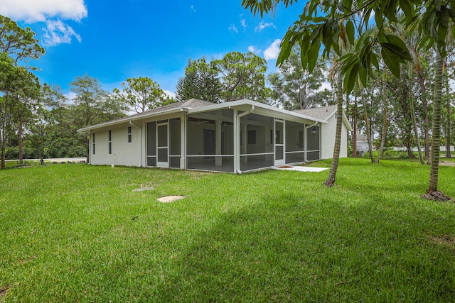 back of house with a lawn and a sunroom