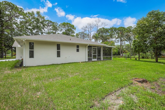 back of property featuring a sunroom and a lawn