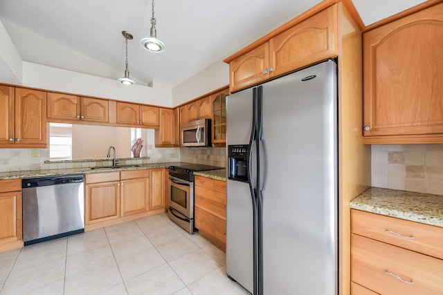 kitchen with stainless steel appliances, hanging light fixtures, sink, light stone countertops, and backsplash