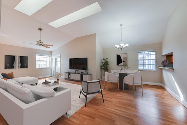 living room with a healthy amount of sunlight, ceiling fan with notable chandelier, and light wood-type flooring