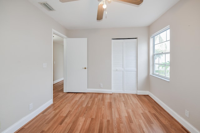 unfurnished bedroom featuring multiple windows, light wood-type flooring, and ceiling fan