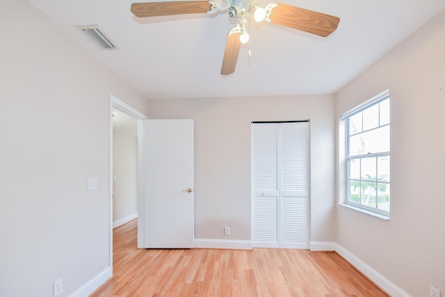 unfurnished bedroom featuring light hardwood / wood-style floors, a closet, and ceiling fan