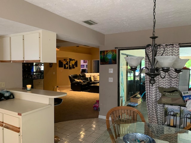 kitchen featuring light carpet, white cabinetry, a textured ceiling, and a healthy amount of sunlight