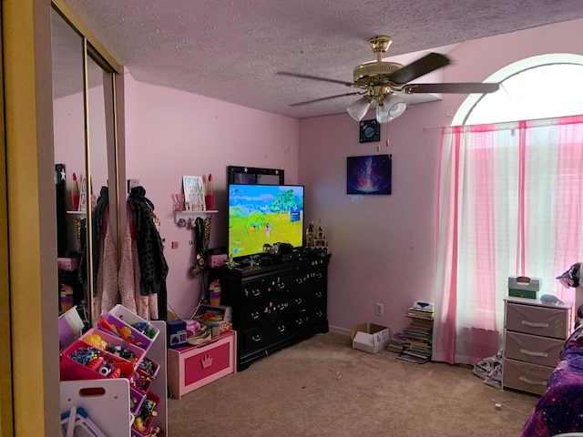 bedroom featuring a textured ceiling, a closet, carpet floors, and ceiling fan