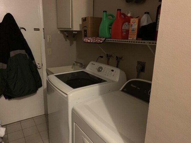 laundry area featuring light tile patterned flooring, sink, and washer and dryer