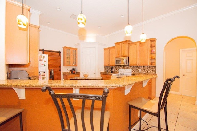 kitchen featuring hanging light fixtures, a barn door, white appliances, kitchen peninsula, and a breakfast bar area