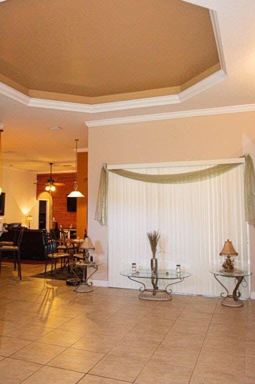 1640 SW Burlington St, Port Saint Lucie, FL 34984 - detailed view of crown molding, ceiling fan, and a raised ceiling