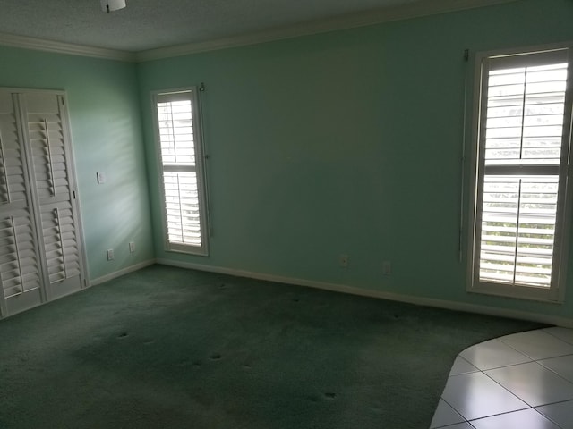 empty room with light tile patterned floors and crown molding