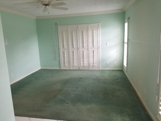 carpeted spare room with ceiling fan and crown molding