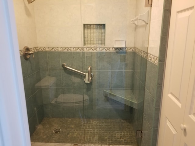 bathroom with toilet and a shower with shower door