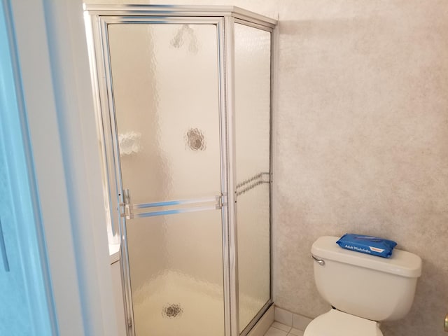 bathroom with an enclosed shower and toilet