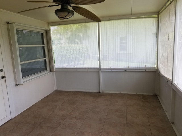 unfurnished sunroom with ceiling fan