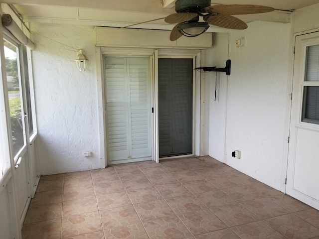 unfurnished sunroom featuring ceiling fan