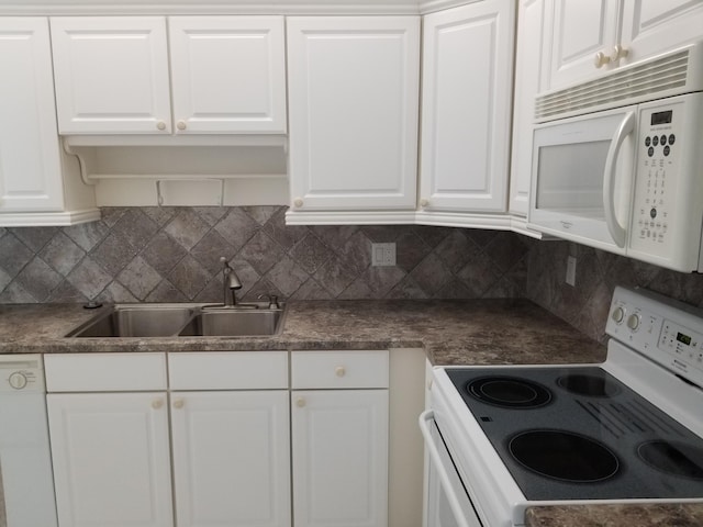 kitchen with decorative backsplash, white cabinets, and white appliances